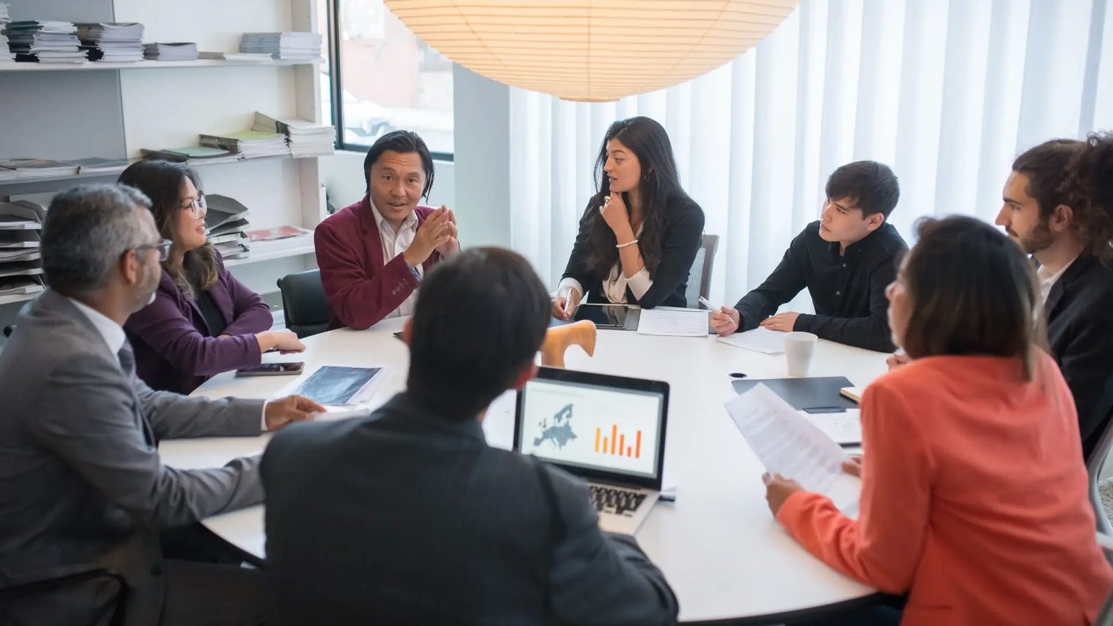 Equipe reunida em mesa redonda em ambiente de trabalho colaborativo